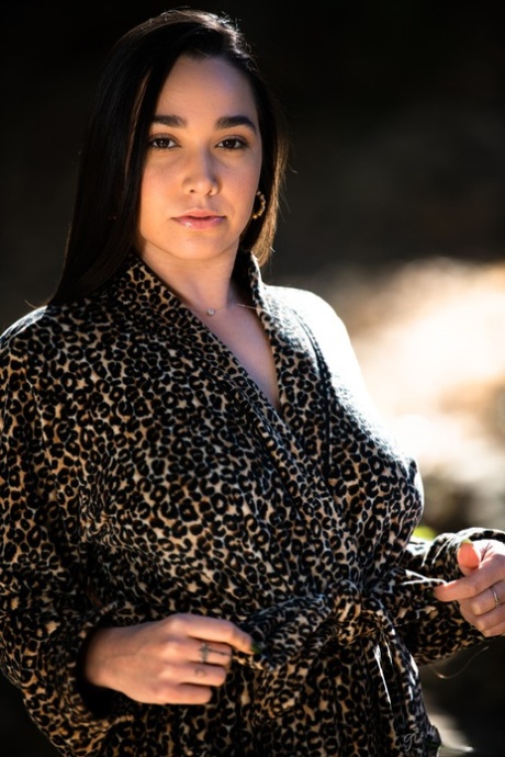 Темноволосая девушка демонстрирует свои натуральные сиськи и сексуальную попку, раздеваясь 1